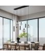 Trio Mataro 364100832 sfeerfoto van hanglamp met brede zwarte plafondbalk en vijf pendels met verchroomd glazen kappen en drie pendels met zwarte cilindervormige kappen voor GU10 lampen boven een gedekte eettafel