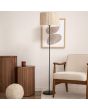 Searchlight Meadow EU49713BK sfeerfoto van vloerlamp met zwarte lampvoet en ronde kap van gras in een zithoek met bruinhouten stoel en tafels met beige textiel
