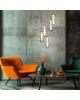 Sfeerfoto van de Trio Minerva hanglamp met zwarte plafondplaat van 42cm met vijf pendels met drie ovale glazen in groen, amber en rookglas boven elkaar met een LED buis in het midden boven een salontafel