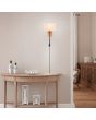 Trio Nilam 212870236 sfeerfoto van landelijke wandlamp met houten wandplaat, rechthoekige creme kap en zwarte leeslamp boven een halfronde houten wandtafel