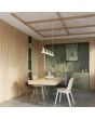 sfeerfoto van beige langwerpige metalen hanglamp van 122 cm lang met vier kegelvormige kapjes aan een stang boven een eettafel in een keuken
