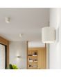 Sfeerfoto van Sollux Orbis beige betonnen cilindervormige wandlamp van 10cm hoog met up en down licht in een woonkamer met meerdere lampen uit dezelfde serie