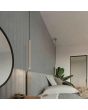 sfeerfoto van twee taupe kleurige hanglampen met buisvormige kap van 500 * 25 mm boven de nachtkastjes naast een bed