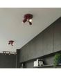 sfeerfoto van twee bordeauxrood metalen plafondspots met ronde plafondplaat van 20 cm in diameter en drie met staaf richtbare spotjes langs een kastenwand