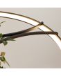 Detailfoto van de brandende LED ring van de zwarte cirkelvormige hanglamp met een diameter van 110 cm met LED in de ring en in het midden twee houders met planten