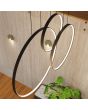 Sfeerfoto van het bovenaanzicht van een zwarte hanglamp Rio met drie verticale ringen in drie formaten, 55, 78 en 110 cm met elk LED aan de binnenzijde in een vide