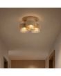 zandkleurige plafondlamp van 42 cm in diameter met drie geribbeld glazen kappen met een messing band aan het plafond van een hal