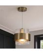 messing kleurige hanglamp van 18 cm in diameter met een geribbeld glazen kap en een messing band eromheen in een woonkamer