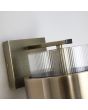bovenzijde messing kleurige wandlamp van 24 cm hoog met een geribbeld glazen kap en een messing band eromheen