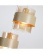 Detailfoto van een kap van de Searchlight Royal hanglamp van 42cm in diameter met zandkleurige ronde plafondplaat en drie pendels zandkleurige metalen band om een cilindervormig amberkleurig ribbelglazen kap