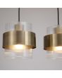 kap van de messing kleurige hanglamp met een lengte van 93 cm en vier pendels met elk een geribbeld glazen kap en een messing band eromheen