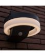 Sfeerfoto onderaanzicht van Lutec Runda antraciet grijze schijfvormige wandlamp van 18 cm breed met kantelbaar zonnepaneel bovenop 