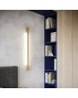 Thoro Sappo TH.202 sfeerfoto van goudkleurige slanke wandlamp voor indirect licht naast een boekenkast