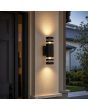 zwart geribbelde up en down wandlamp voor buiten van 19 cm hoog met twee transparante ringen per zijde naast een voordeur