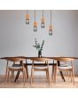 Trio Tosh 304300432 sfeerfoto van hanglamp met zwarte plafondbalk en vier cilindervormige kapjes met hout van boven en zwart gaas van onder boven een landelijke eettafel