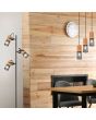 Trio Tosh 304330332 sfeerfoto van hanglamp met zwarte ronde plafondplaat en drie cilindervormige kapjes met hout van boven en zwart gaas van onder boven een houten eettafel met vloerlamp uit dezefde serie er naast