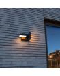 Sfeerfoto van Lutec Twisto antraciet grijze wandlamp voor buiten van 15,1 cm hoog met een naar beneden gerichte en naar rechts gerichte draaibaar LED paneel