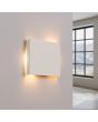 brandende wit vierkant metalen wandlamp van 15 cm in doorsnede met lichtbundel naar boven en beneden.