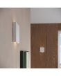 closeup sfeerfoto van wit vierkant metalen wandlamp van 15 cm in doorsnede met lichtbundel naar boven en beneden.