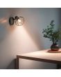 Sfeerfoto van Casalum Yako zwarte spot van 14 cm hoog met kapje van gevlochten metaaldraad boven een houten tafel met een plant