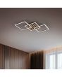 Sfeerfoto van Reality Zaro zwarte plafondlamp van 73,5 cm lang met een vierkante plafondplaat met vijf houtkleurige balkjes en LED rand eromheen en twee draaibare vierkante raamwerken met geïntegreerde LED aan een plafond in een ruimte met houten muren en